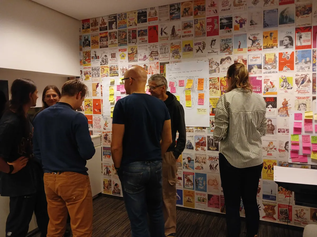 Team standing in front of a wall of posters